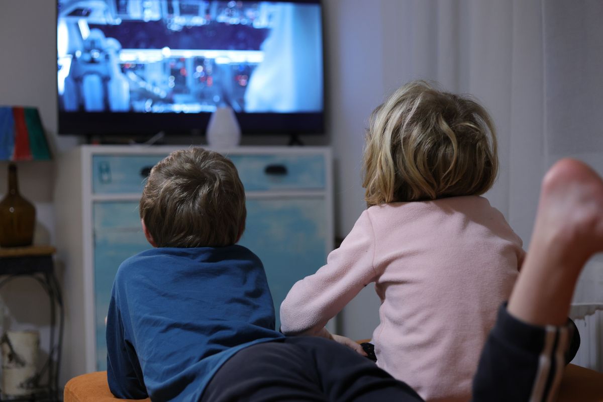 Two kids watching TV in the livingroom