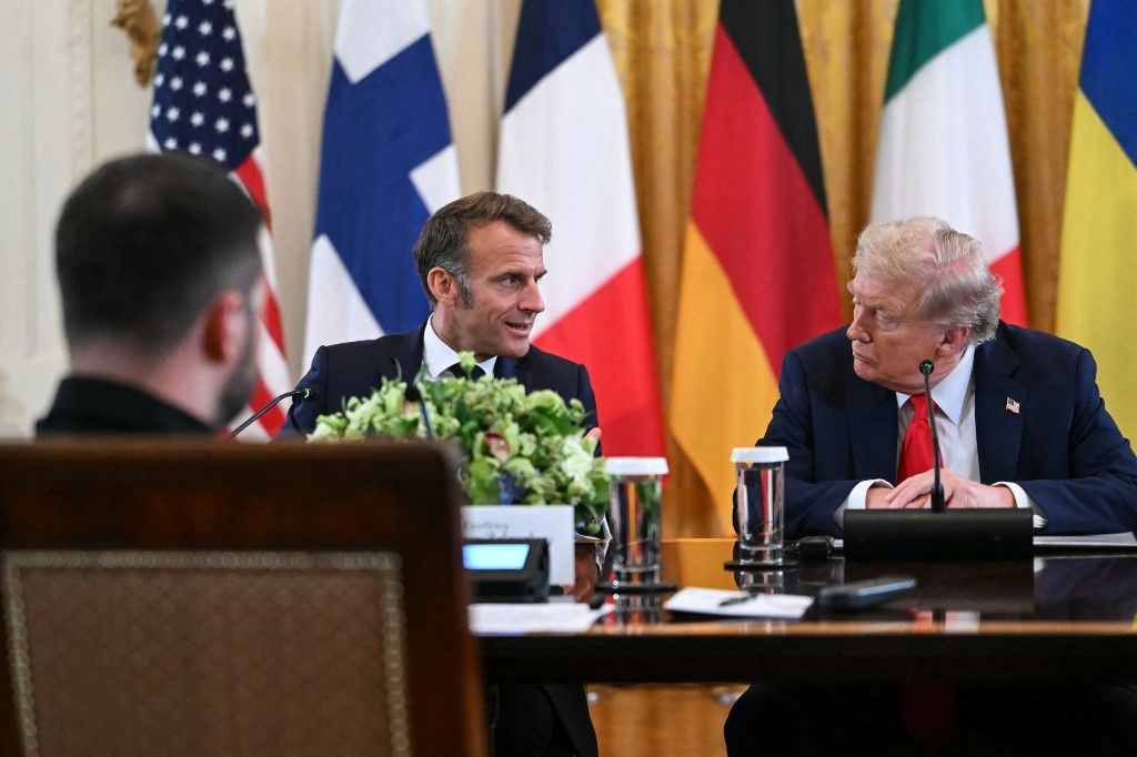 (L/R) Ukrainian President Volodymyr Zelensky, French President Emmanuel Macron and US President Donald Trump participate in a meeting with European leaders in the East Room of the White House in Washington, DC, on August 18, 2025. European leaders join Ukrainian President Volodymyr Zelensky in talks with US President Donald Trump on August 18, as they try to find a way to end Russia's offensive. The leaders heading to Washington on Monday to appear alongside Zelensky call themselves the "coalition of the willing." (Photo by ANDREW CABALLERO-REYNOLDS / AFP)
