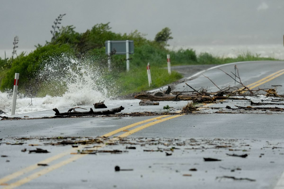 The wind blows the high tide onto roads during a rare Red Wind Warning in Wellington on October 23, 2025. (Photo by Marty MELVILLE / AFP)