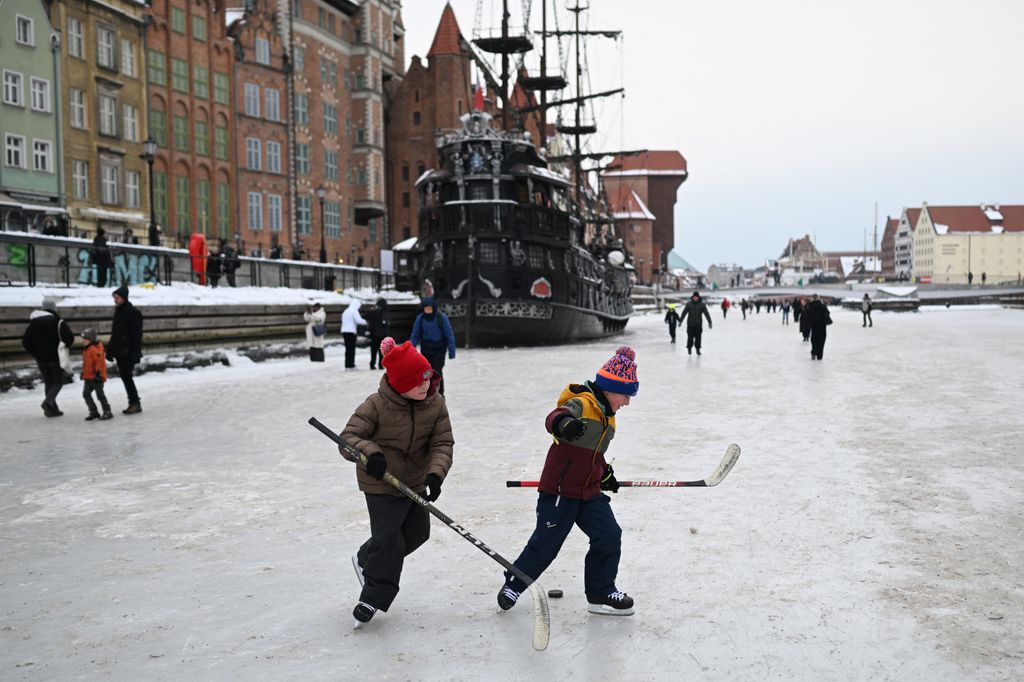 Lengyelország - Gyerekek hokiznak a befagyott Motława folyón Gdańsk központjában