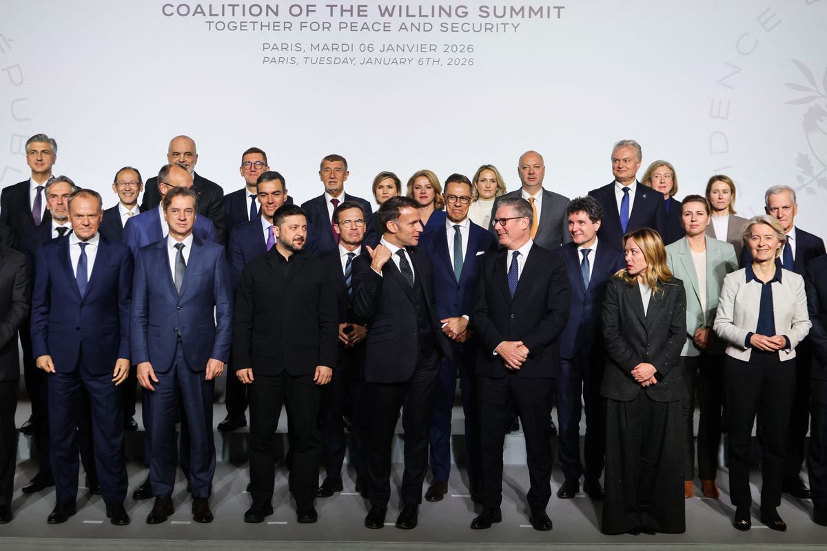 France's President Emmanuel Macron (C) and Britain's Prime Minister Keir Starmer (3rd R) speak as they pose with (front row from L) Poland's Prime Minister Donald Tusk, Slovenia's Prime Minister Robert Golob, Ukraine's President Volodymyr Zelensky, Italy's Prime Minister Giorgia Meloni and European Commission President Ursula Von der Leyen for a family photo at the Elysee Palace in Paris, on January 6, 2026, on the sideline of the Coalition of the Willing summit on security guarantees for Ukraine. The summit of the group of Ukraine supporters dubbed the "Coalition of the Willing" is the latest of several meetings planned for the new year as diplomatic efforts to end Europe's deadliest conflict since World War II have gained pace in recent weeks. (Photo by Ludovic MARIN / POOL / AFP)