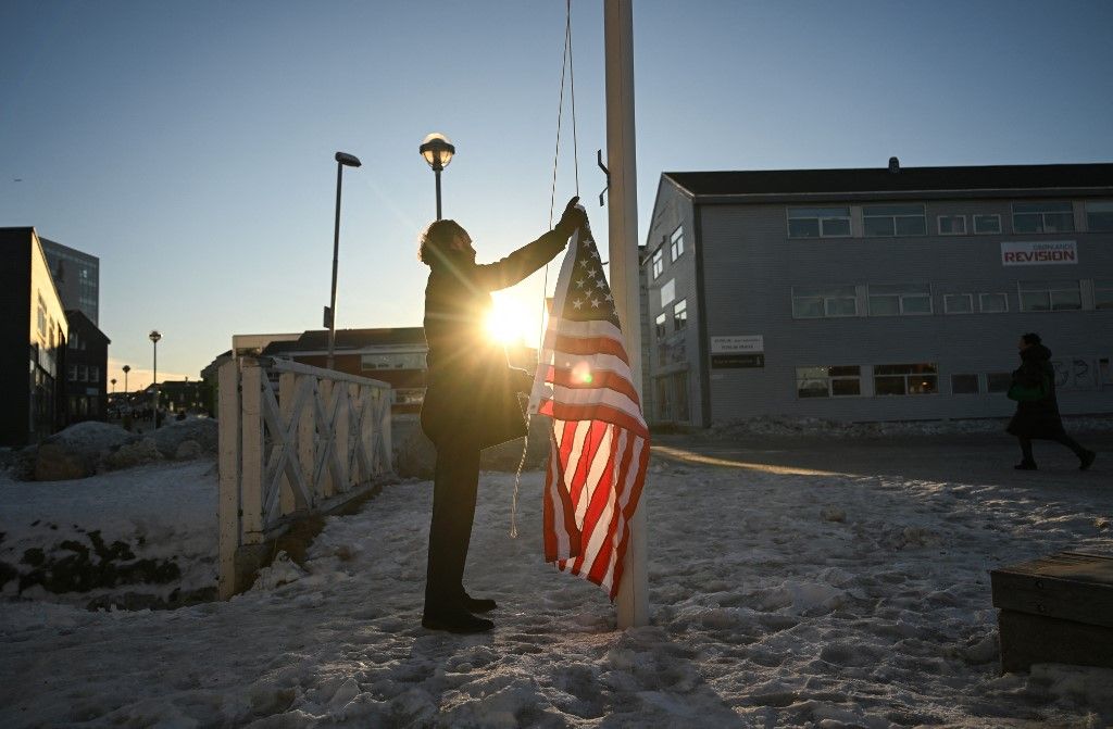 German Comedian Maxi Schafroth tries to rise an American flag in the city of Nuuk, western Greenland, on January 28, 2026. (Photo by Ina FASSBENDER / AFP)