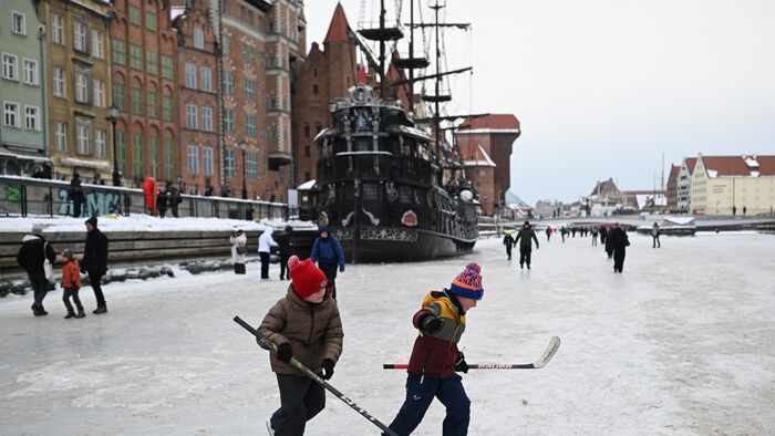 Lengyelország - Gyerekek hokiznak a befagyott Motława folyón Gdańsk központjában