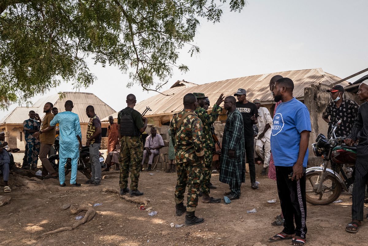 Members of the NIgeria Armed Forces interact with residents following the attack in Woro, Kwara State, on February 5, 2026. Details are still emerging from the attack in Kwara State, but it is one of the country's deadliest in recent months. According to the Red Cross, the death toll stands at 162 people, and the search for bodies is ongoing. (Photo by Light Oriye Tamunotonye / AFP) Nigéria