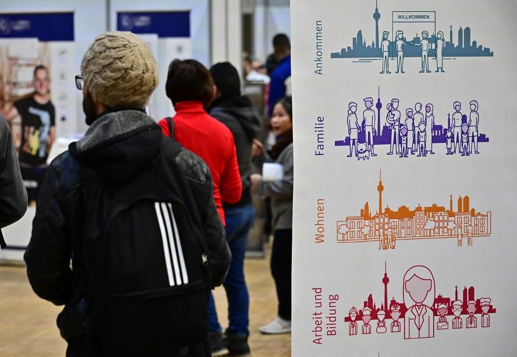 A visitor walks through a job fair for migrants launched by the German job center (Bundesagentur für Arbeit) in Berlin on January 28, 2019. (Photo by Tobias SCHWARZ / AFP)
