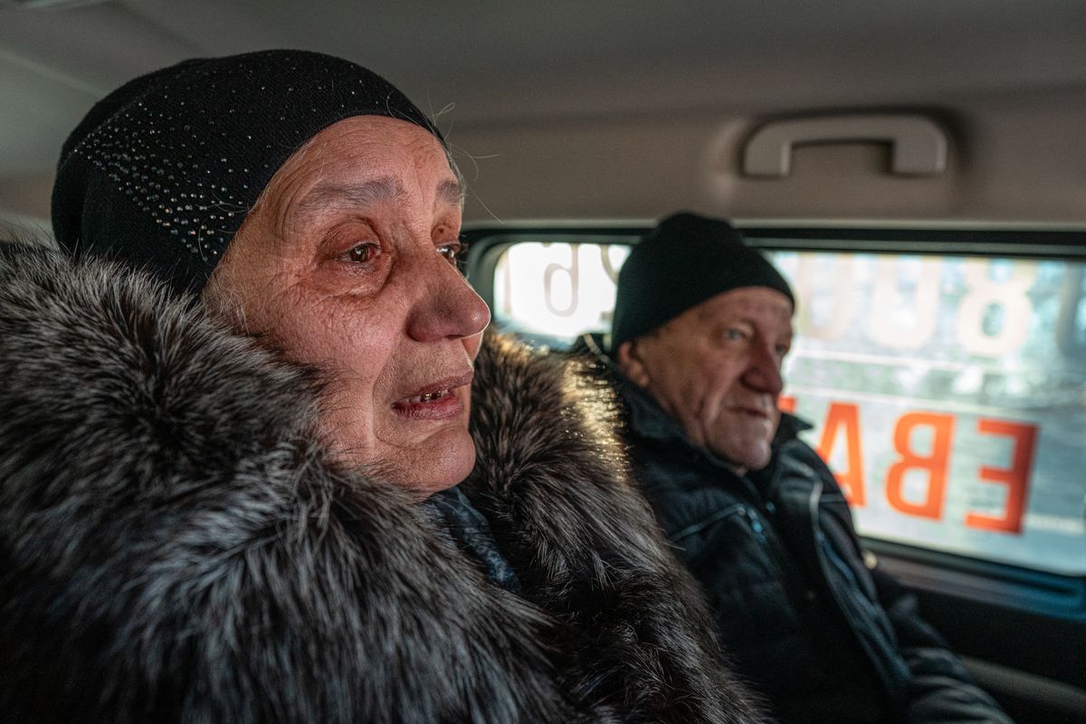 Egy síró asszony úton az utolsó, civileket evakuáló vonat irányába