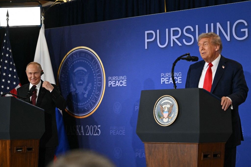 Russian President Vladimir Putin (L) smiles as US President Donald Trump speaks during a joint press conference after they participated in a US-Russia summit on Ukraine at Joint Base Elmendorf-Richardson in Anchorage, Alaska, on August 15, 2025. (Photo by ANDREW CABALLERO-REYNOLDS / AFP)