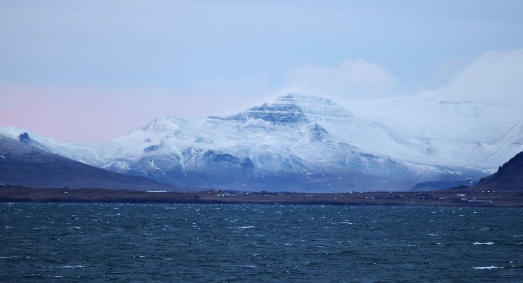 REYKJAVIK, ICELAND - NOVEMBER 29: Snow-capped mountains are seen in Reykjavik, surrounded by the Arctic Ocean while it attracts tourists with its colorful houses and nature in Iceland on November 29, 2025. Veysel Altun / Anadolu (Photo by Veysel Altun / Anadolu via AFP)