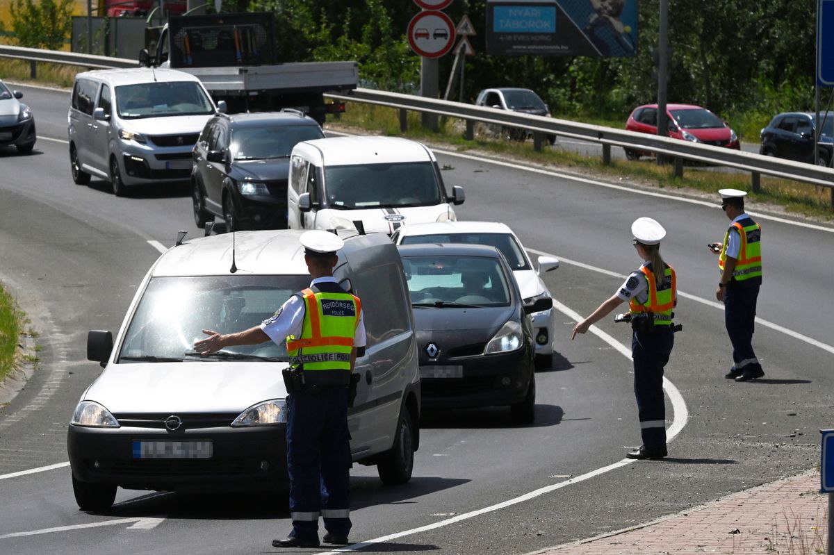 Dunakeszi, 2025. június 16.
Rendőrök légalkoholmérés miatt állítank meg járművezetőket Dunakeszin, az M0-ás autóút előtti körforgalomnál 2025. június 16-án. Az Európai Közlekedésrendészeti Szervek Hálózata Műveleti Csoportjának (ROADPOL) éves ellenőrzési terve alapján június 16. és 22. között tart a rendőrség országos akciót, amelyben a járművezetők ittas és bódult állapotát szűrik ki.
MTI/Lakatos Péter
