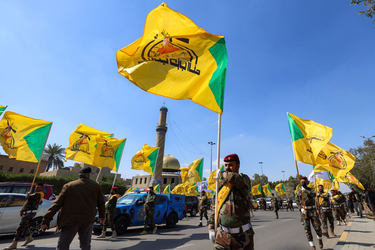Members of Iraq's pro-Iran paramilitary group Hezbollah Brigades (Kataeb Hezbollah) march with the group's banners in a funeral for slain fighters killed in a US-Israeli airstrike on their headquarters in al-Qaim near the border with Syria, during a ceremony in Baghdad on March 2, 2026. Eight Iran-backed fighters were killed on March 1 in separate strikes in Iraq, as the region was embroiled in violence after the United States and Israel launched strikes on Iran. (Photo by AHMAD AL-RUBAYE / AFP)
