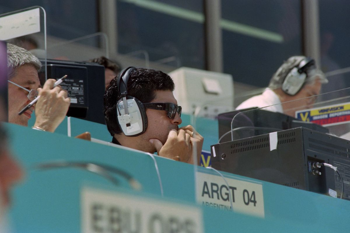 Suspended Argentinan soccer star Diego Maradona sits at a TV boradcast desk watching the World Cup match between Argentina and Romania on July 3, 1994 at Los Angeles. (Photo by Romeo GACAD / AFP)