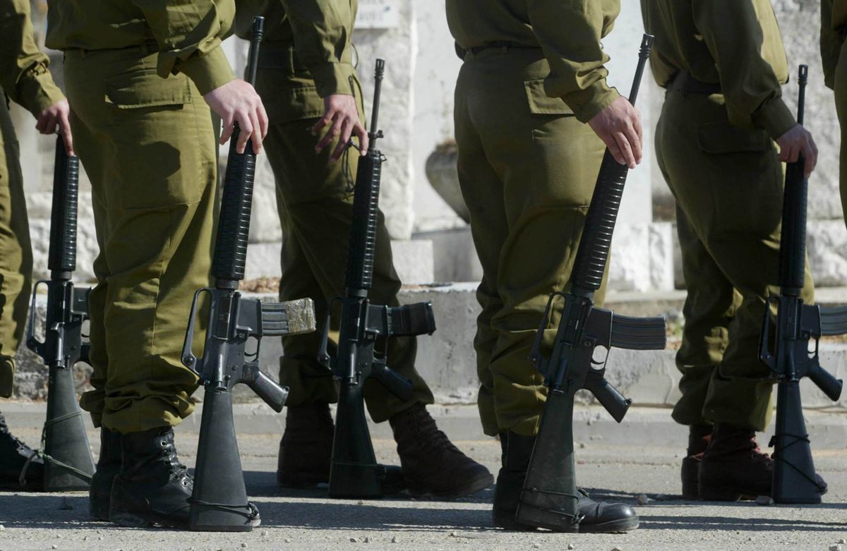PETAKH TIKVA, ISRAEL - APRIL 4: Israeli soldiers wait for the body of Kobi Zaga to be brought for burial April 4, 2004 during his funeral at the Segula grave yard close to the city of Petakh Tikva, Israel. Zaga was killed two days ago when a Palestinian militant entered the settlement of Avnei Hefez, close to the West Bank city of Tulkarem, and opened fire before being gunned down by Israeli troops.