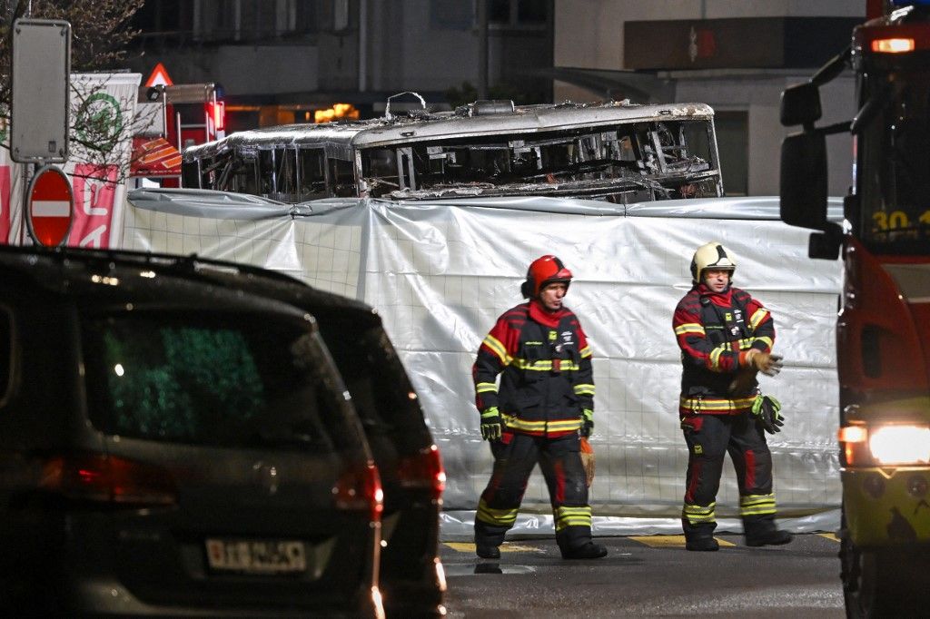 Firemen work outside a blocked off area in front of a bus that caught fire, leaving six people dead and several injured, in the town of Kerzers, western Switzerland, on March 10, 2026. (Photo by Fabrice COFFRINI / AFP)