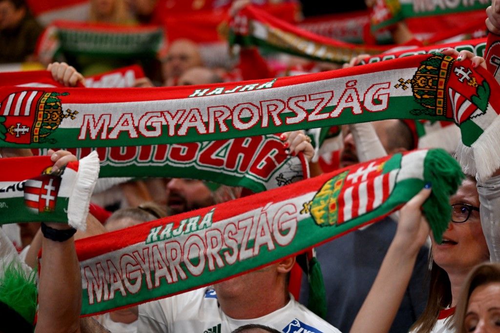 14 January 2024, Bavaria, Munich: Handball: European Championship, Serbia - Hungary, preliminary round, Group C, match day 2. Hungarian fans hold up scarves. Photo: Peter Kneffel/dpa (Photo by PETER KNEFFEL / dpa Picture-Alliance via AFP)