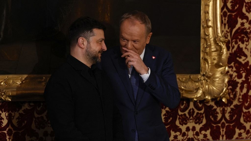 Polish Prime Minister Donald Tusk and Ukrainian President Volodymyr Zelensky react prior to the traditional dinner on the occasion of the Munich Security Conference (MSC), on February 14, 2026 at the Munich Residence palace in Munich, southern Germany. (Photo by Michaela STACHE / AFP)