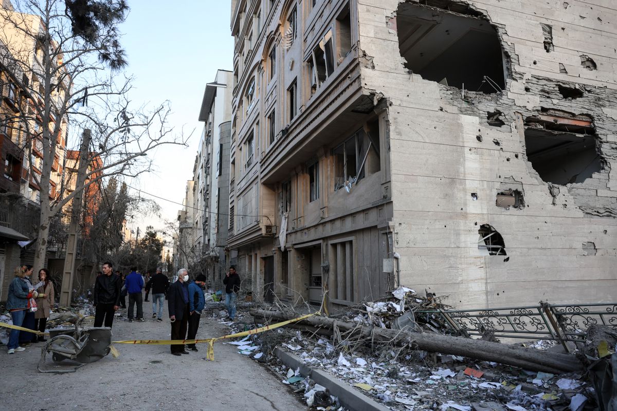 Residents stand on a street beside damaged residential buildings near Niloufar square in Tehran during the ongoing joint US-Israeli military campaign on Iran on March 2, 2026. The United States and Israel launched strikes against Iran on February 28, killing Iran's supreme leader and top military leaders, prompting authorities to retaliate with strikes on Israel and across the Gulf. (Photo by AFP)
