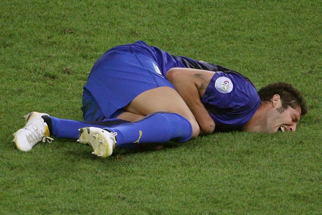 Italian defender Marco Materazzi lies on the pitch after receiving a head butt by French midfielder Zinedine Zidane during the World Cup 2006 final football match between Italy and France at Berlins Olympic Stadium, 09 July 2006.  AFP PHOTO/JOHN MACDOUGALL (Photo by JOHN MACDOUGALL / AFP)