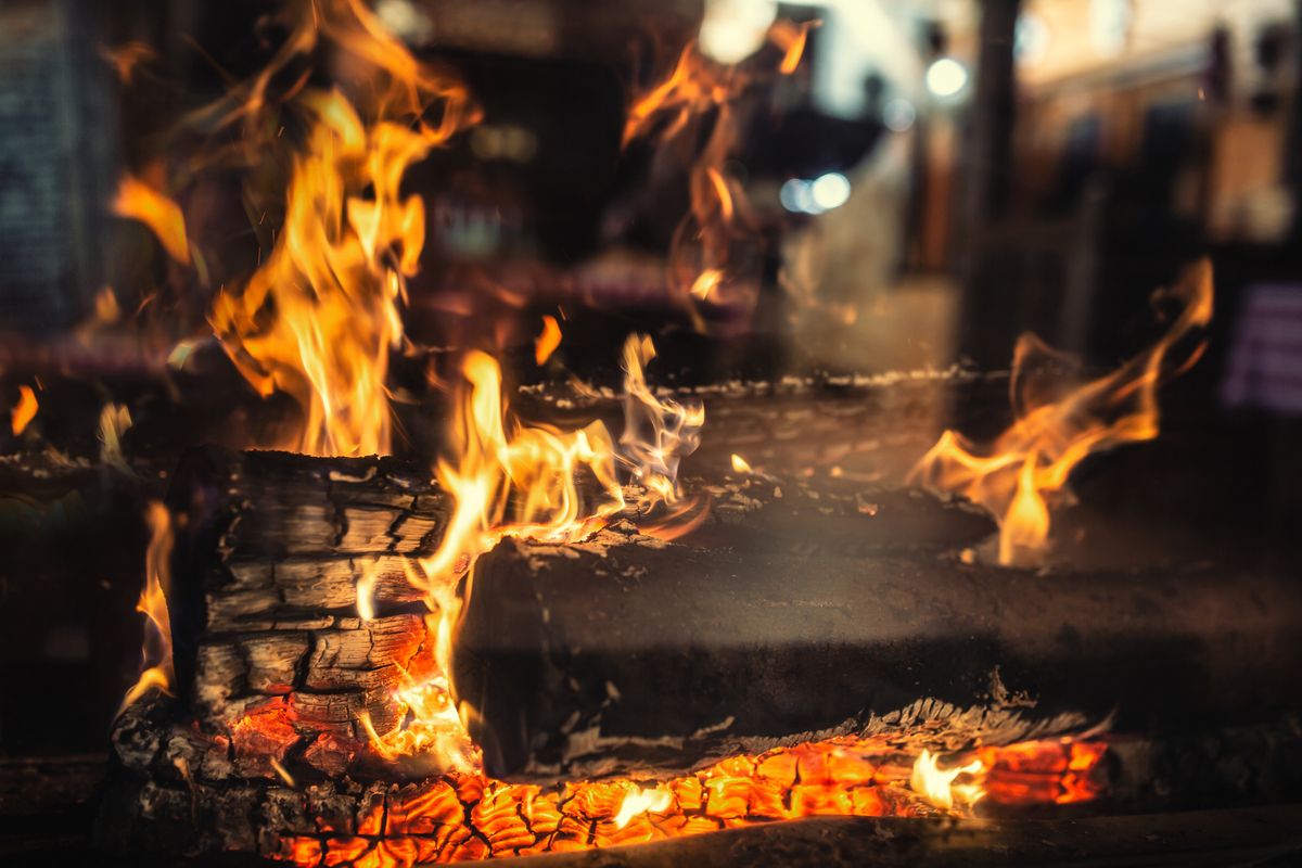 Detail of a transparent home fireplace with burning wood.