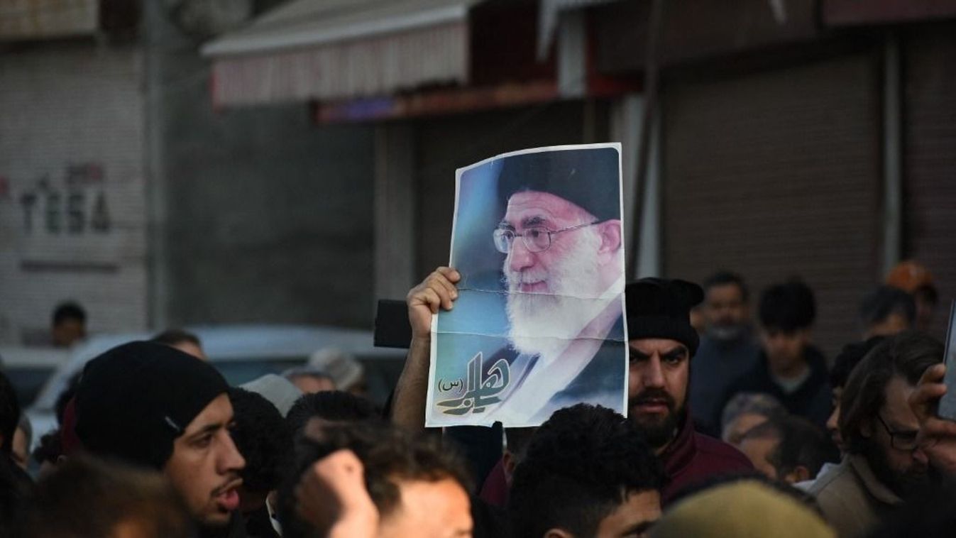 Ali Hamenei képét tartó személy a tömegben