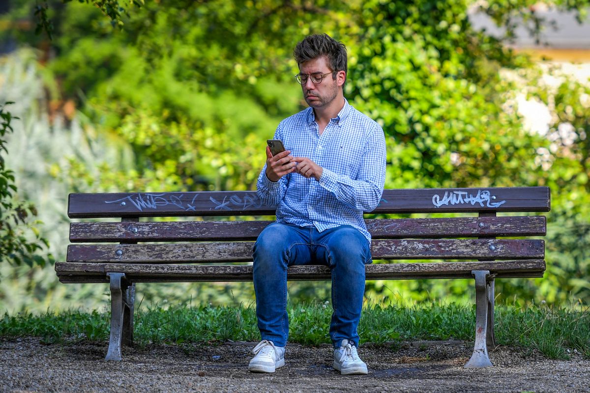 Hungarian investigative journalist Szabolcs Panyi, whose number was on a leaked list of phones reportedly being targeted by Isreali-made spyware, looks at his mobile phone on July 20, 2021 in Budapest. Claims that Hungary used Israeli-made spyware to target journalists and others have increased concerns about media freedom in the EU member governed by nationalist Prime Minister Viktor Orban. (Photo by GERGELY BESENYEI / AFP)