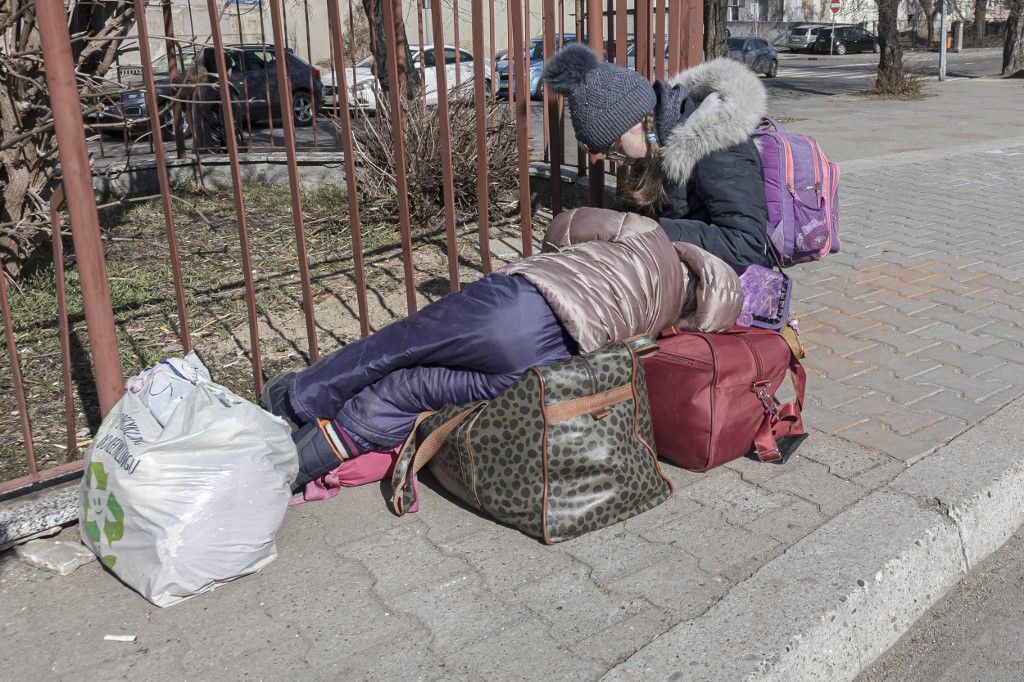A devasted mother just arrived in Poland as seen talking on the phone and crying next to her children. War refugees from Ukraine arrive at Przemysl railway station and get warm food. Civilians mostly women, old people and children who fled the conflict in Ukraine are seen in train station in Przemyl getting warm food from volunteers and Polish armed forces. Afterwards they register to get on buses or trains at the main railway station to be transferred into Poland and Europe while volunteers and NGOs provide them with humanitarian aid and assistance. People arrive by train from Lviv in Ukraine or from Medyka - Shehyni border crossing, where most of them cross the Polish Ukrainian borders on foot and arrive at the station by bus. According to UN - UNHCR about 8 million refugees left the country as United Nations announced and showed the data on a map of the Ukrainians who fled and those who have been internally displaced. Przemysl, Poland on March 2022 (Photo by Nicolas Economou/NurPhoto) (Photo by Nicolas Economou / NurPhoto via AFP)
