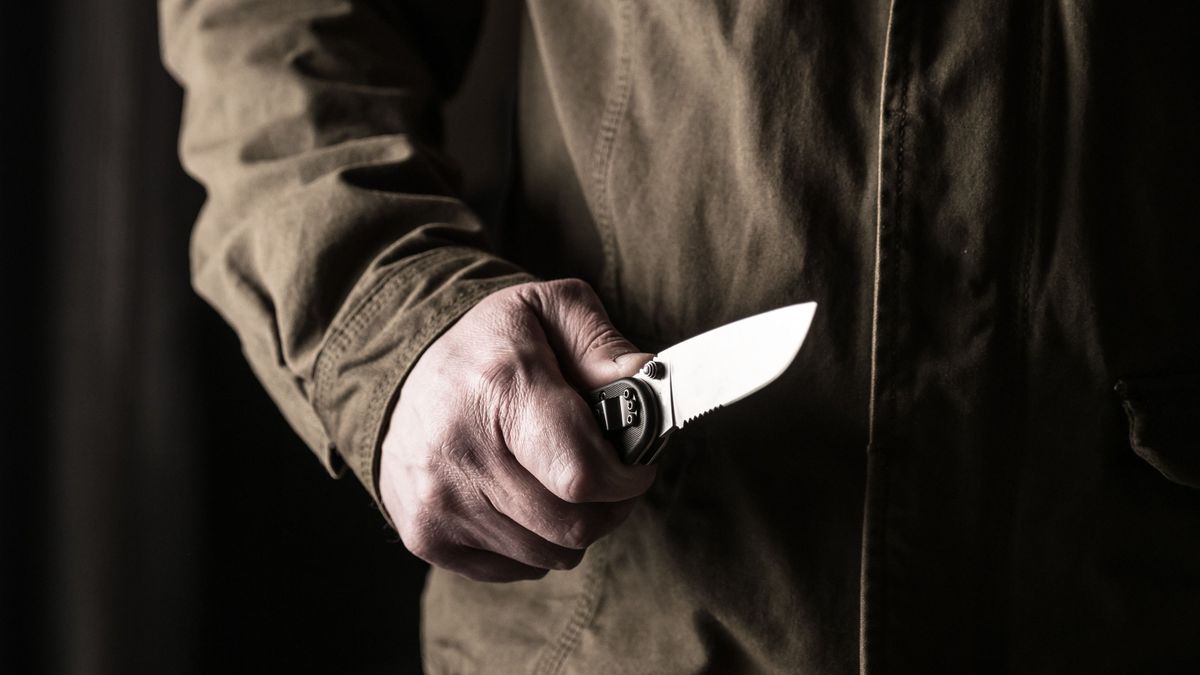 Man holding a knife in a threatening stance ready to fight