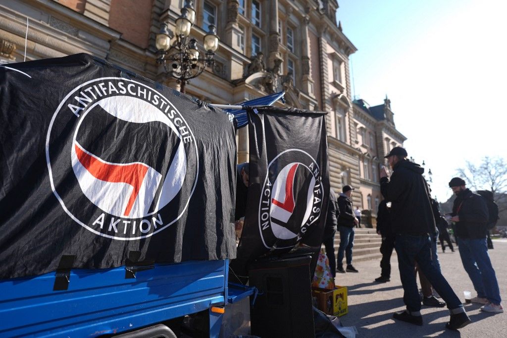 05 March 2026, Hamburg: Members of left-wing groups and the Antifa scene demonstrate in front of the criminal court building where the trial against the extreme right-wing terrorist group "Letzte Verteidigungswelle" (Last Wave of Defense) begins. Most of the accused, some of whom are very young, are said to be members of a domestic terrorist organization and are charged with attempted murder, conspiracy to commit murder and grievous bodily harm. Photo: Marcus Brandt/dpa (Photo by MARCUS BRANDT / dpa Picture-Alliance via AFP)