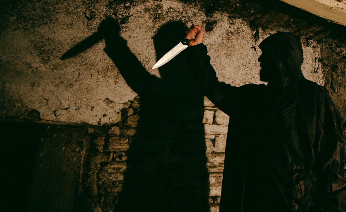 murderer with big knife and shadow horror scene