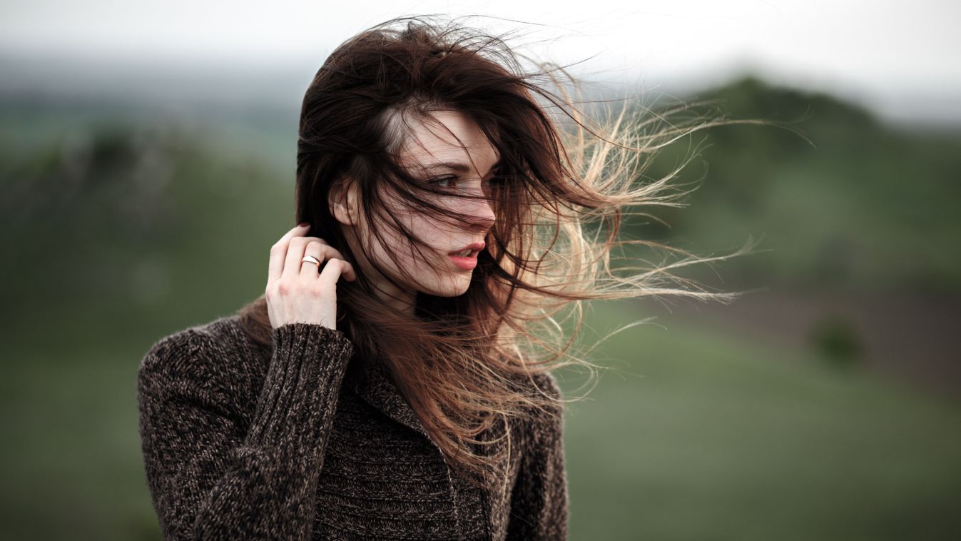 Portrait of beautiful young woman standing on the cliff, watching the last light. Hair blowing in the wind.Girl admiring mountain landscape. A woman standing alone in sunset scene

1014429700