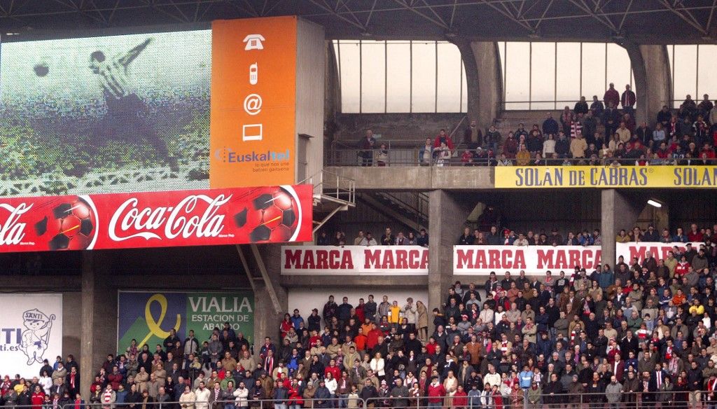 Athletic Bilbao supporters observe a minutes silence inememberance of famous player Telmo Zarraonaindia "Zarra" while his image appears on a screen (L), 26 February 2006, prior to a Spanish league football match against Villarreal at the San Mames stadium, in Bilbao. "Zarra" died 23 February 2006 in Bilbao, aged 85.   AFP PHOTO / Rafa RIVAS (Photo by RAFA RIVAS / AFP)