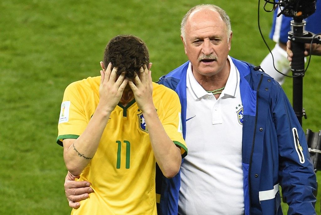 Brazil's coach Luiz Felipe Scolari (R) consoles Brazil's midfielder Oscar after losing the semi-final football match between Brazil and Germany at The Mineirao Stadium in Belo Horizonte on July 8, 2014, during the 2014 FIFA World Cup. AFP PHOTO / ODD ANDERSEN (Photo by ODD ANDERSEN / AFP)