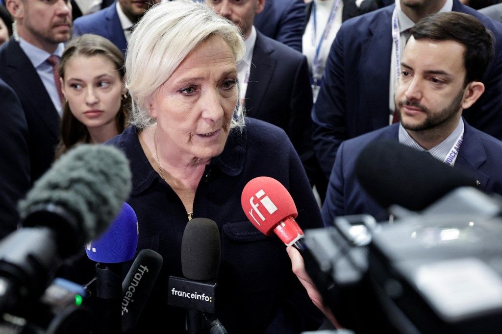 Far-right Rassemblement National (RN) parliamentary group president Marine Le Pen (C) and Rassemblement National's MP Jean-Philippe Tanguy (R) speak to the press as they visit the Global Industrie trade show at the Paris Nord Villepinte exhibition centre in Villepinte,  northeast of Paris, on April 1, 2026. (Photo by STEPHANE DE SAKUTIN / AFP)