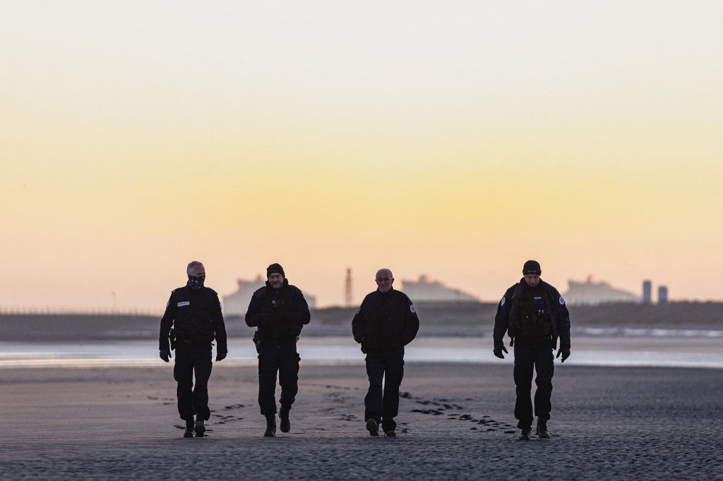 French police officers patrol the Gravlelines beach at sunrise in a bid to prevent migrants from crossing the English Channel, in Gravelines, northern France on April 14, 2026. (Photo by Sameer Al-DOUMY / AFP)