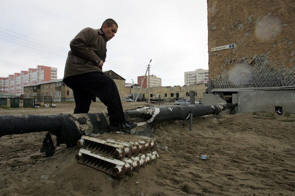A local resident steps over a heating tube at social housing area in a town of Novy Urengoy, West Siberia, 15 June 2006. Urengoy gas field is the world's second largest natural gas field, with over ten trillion cubic meters (10¹³ m³) in total deposits. It lies in Yamalo-Nenets Autonomous Okrug in Tyumen Oblast (region) of Russia, just south of the Arctic circle and is named after the settlement of Urengoy. Novy Urengoy is home to 110,000 people, most of whom are employed by OAO Gazprom, the world's largest gas producer. Discovered in June 1966, the field started production in 1978. In February 1981 Urengoy produced its first one hundred billion cubic meters (109 m³) of natural gas. From January 1984 Urengoy gas started to be exported to Western Europe. It continues to produce over two hundred billion cubic meters of gas per year. AFP PHOTO MAXIM NARMUR 
AFP PHOTO / MAXIM MARMUR (Photo by MAXIM MARMUR / AFP)