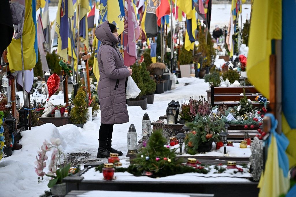 LVIV, UKRAINE - FEBRUARY 22: People visit the graves of Ukrainian soldiers who lost their lives during the Russian-Ukrainian war at the Lychakiv Cemetery in Lviv, Ukraine on February 22, 2026. After four years of full-scale war, the field of honor burials at the cemetery designated for military burials is completely filled. Now the soldiers are buried in another field, which was created after the dismantling of the Soviet Hill of Glory. Michael Sorrow / Anadolu (Photo by Michael Sorrow / Anadolu via AFP)