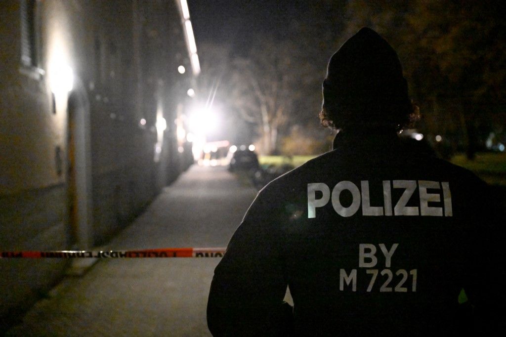 19 March 2026, Bavaria, Munich: A police officer stands at a cordon in front of a house where a woman was found dead. Initially, an emergency call was received about an injured woman in an apartment, the police said in the evening. On site, however, the officers only found the lifeless woman. There were indications that she was not at fault and a male suspect had been arrested. Photo: Felix Hörhager/dpa (Photo by Felix Hörhager / dpa Picture-Alliance via AFP)