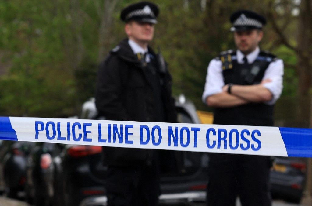 Police officers stand on duty at a cordon near to the Finchley Reform Synagogue, in the North Finchley area of north London, on April 15, 2026, following an attack on the synagogue in the early hours of the morning. Britain's Metropolitan Police said on April 15 they are seeking two suspects following an attempted arson attack at Finchley Reform Synagogue in north London, where bottles thought to have  contained petrol were thrown at the building. (Photo by Toby Shepheard / AFP)