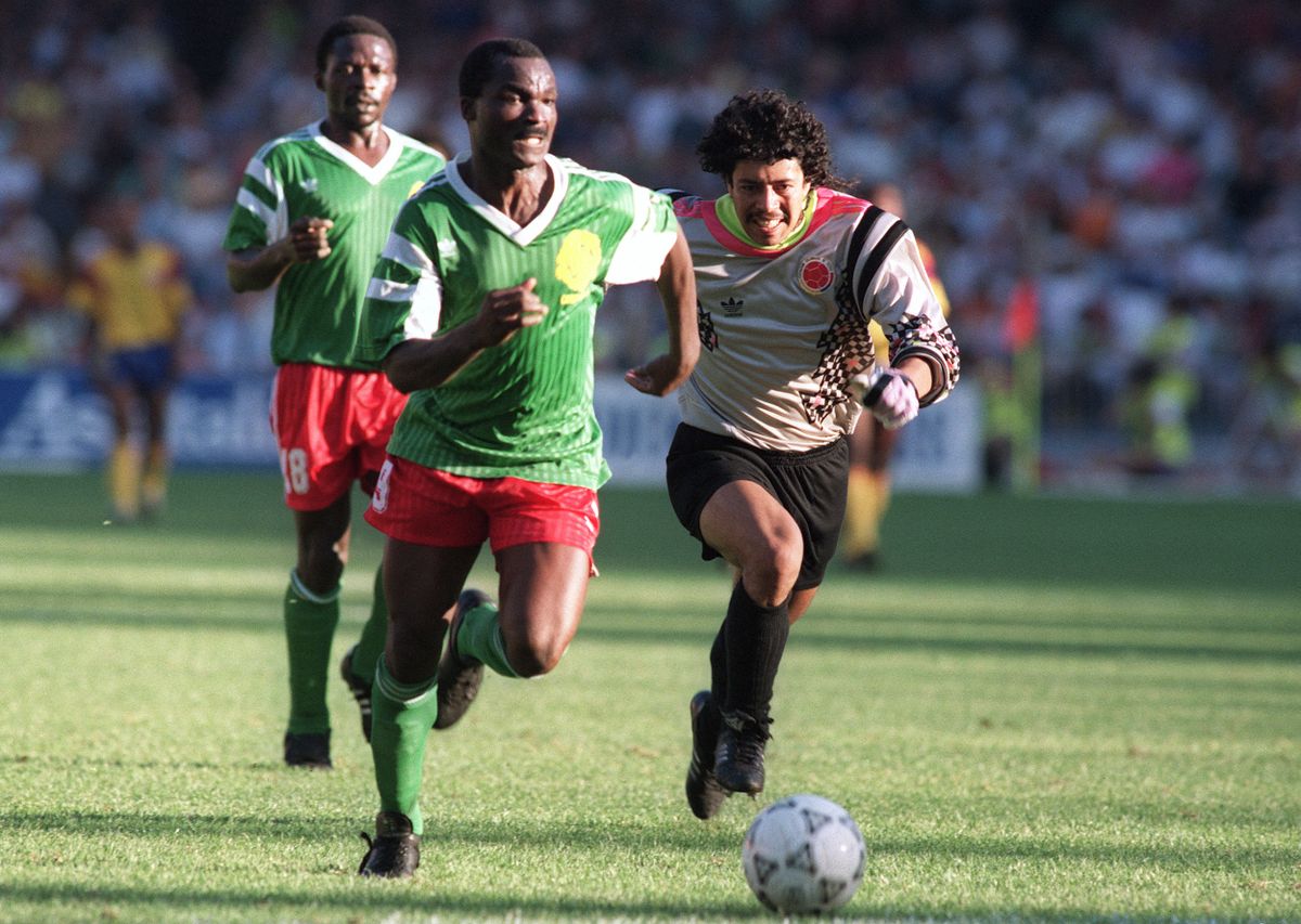 Forward Roger Milla from Cameroon runs past Colombian goalkeeper Jose Higuita (R) after stealing the ball from him on his way to score a goal 23 June 1990 in Naples during the World Cup second round soccer match between Cameroon and Colombia. Milla scored two goals in extra time to help Cameroon defeat Colombia 2-1 (0-0 at the end of regulation time) (Photo by AFP)