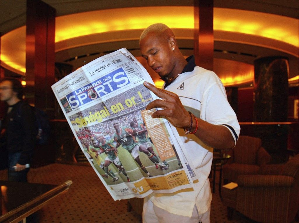 Senegal national team striker El Hadji Diouf reads a French newspaper 18 June 2002 in Osaka, where the Senegalese squad prepares its quarter-finals of the FIFA 2002 World Cup against Turkey scheduled 22 June.   AFP PHOTO - Patrick HERTZOG (Photo by PATRICK HERTZOG / AFP)