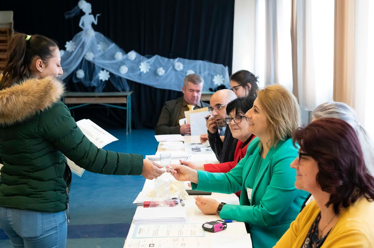 Nyíregyháza, 2022. április 3.
Először szavazó nő átveszi az első szavazóknak járó ajándékot, egy jelvényt az országgyűlési választáson és gyermekvédelmi népszavazáson a Nyíregyházához tartozó Butykatelepen, a közösségi házban 2022. április 3-án.
MTI/Balázs Attila