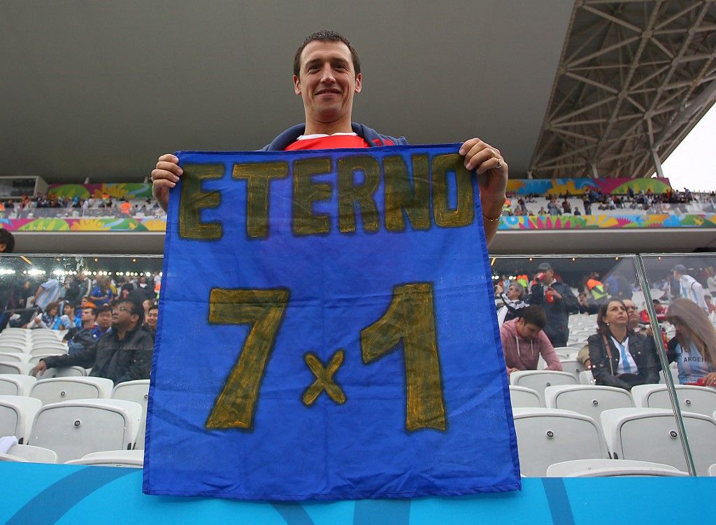 An Argentina supporter holds a banner with the result of last night's Germany vs Brazil semi final, 7-1 during the 2014 FIFA World Cup football match, demi Final between Netherlands and Brazil on July 09, 2014 at Arena Sao Paulo (BRA), Brazil - Photo Kieran McManus / BPI / DPPI (Photo by KIERAN McMANUS / BACKPAGE IMAGES Ltd / DPPI via AFP)