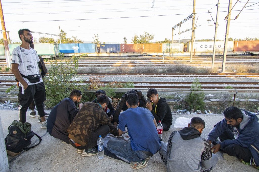 Asylum seekers as seen at Idomeni railway station, a few meters before the borderline between Greece and Northern Macedonia as seen resting and eating. They wait and form groups to cross the borders in the mountains and reach other European countries like Germany, France, Sweden etc via the Balkan route.  Refugees and migrants arrive at the train station from Turkey or Thessaloniki after a long multi-day journey on foot following marked routes in social media or the rails and highway but others via smugglers paying sometimes 2500 euro to smugglers to move them from Turkey here. Some of them complained for pushbacks from the N. Macedonian police after treating them violently and beating them. The station and the fenced part of the borders were guarded by Greek police and European Frontex forces. Most of the group were from Afghanistan, some from Syria, Iraq, Palestine, Pakistan, and Morocco. The flows of people arriving from Turkey are increasing every day as the refugee and migrant crisis is still ongoing. Eidomeni, Greece on October 2022  (Photo by Nicolas Economou/NurPhoto) (Photo by Nicolas Economou / NurPhoto via AFP)