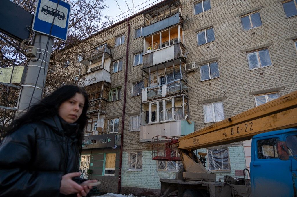 A woman walks past a damaged apartment building at the site of a recent Ukrainian missile strike in Bryansk on March 11, 2026. A Ukrainian missile strike on the western Russian city of Bryansk killed seven people and wounded 42, according to the region's governor's latest update. (Photo by Andrey BORODULIN / AFP)