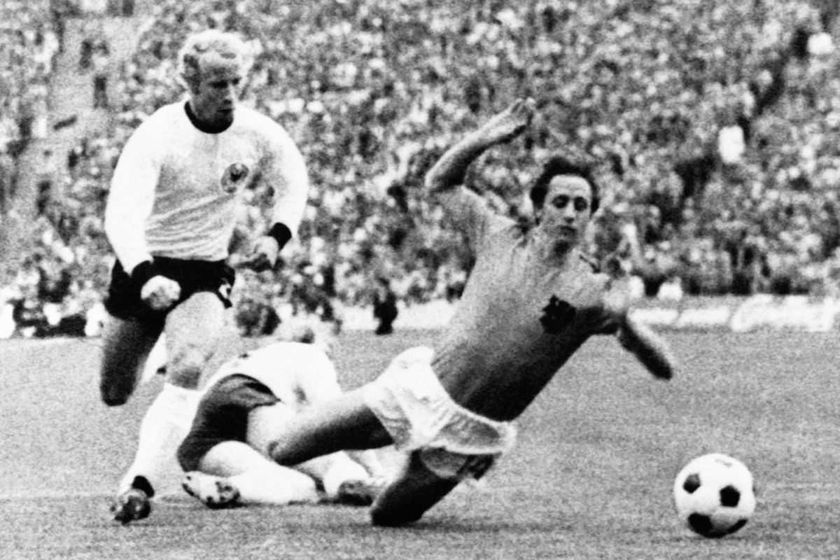 Holland's Johan Cruyff is being hooked by Germany's Hans-Hubert Vogts and Holland scoring 1-0 through Neeskens on the following penalty kick during the World cup soccer final "West Germany - Holland" at Olympic Stadium in Munich on July 07, 1974. (Photo by AFP)