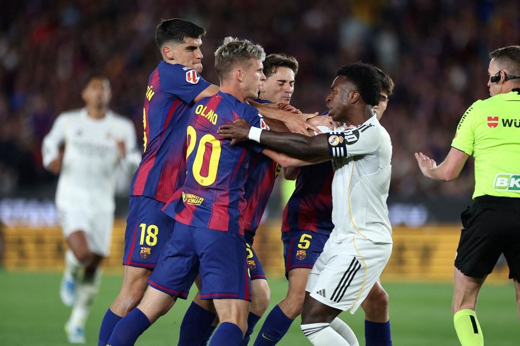 Real Madrid's Brazilian forward #07 Vinicius Junior clashes with Barcelona's players during the Spanish league football match between FC Barcelona and Real Madrid CF at Camp Nou Stadium in Barcelona on May 10, 2026. (Photo by Josep LAGO / AFP)