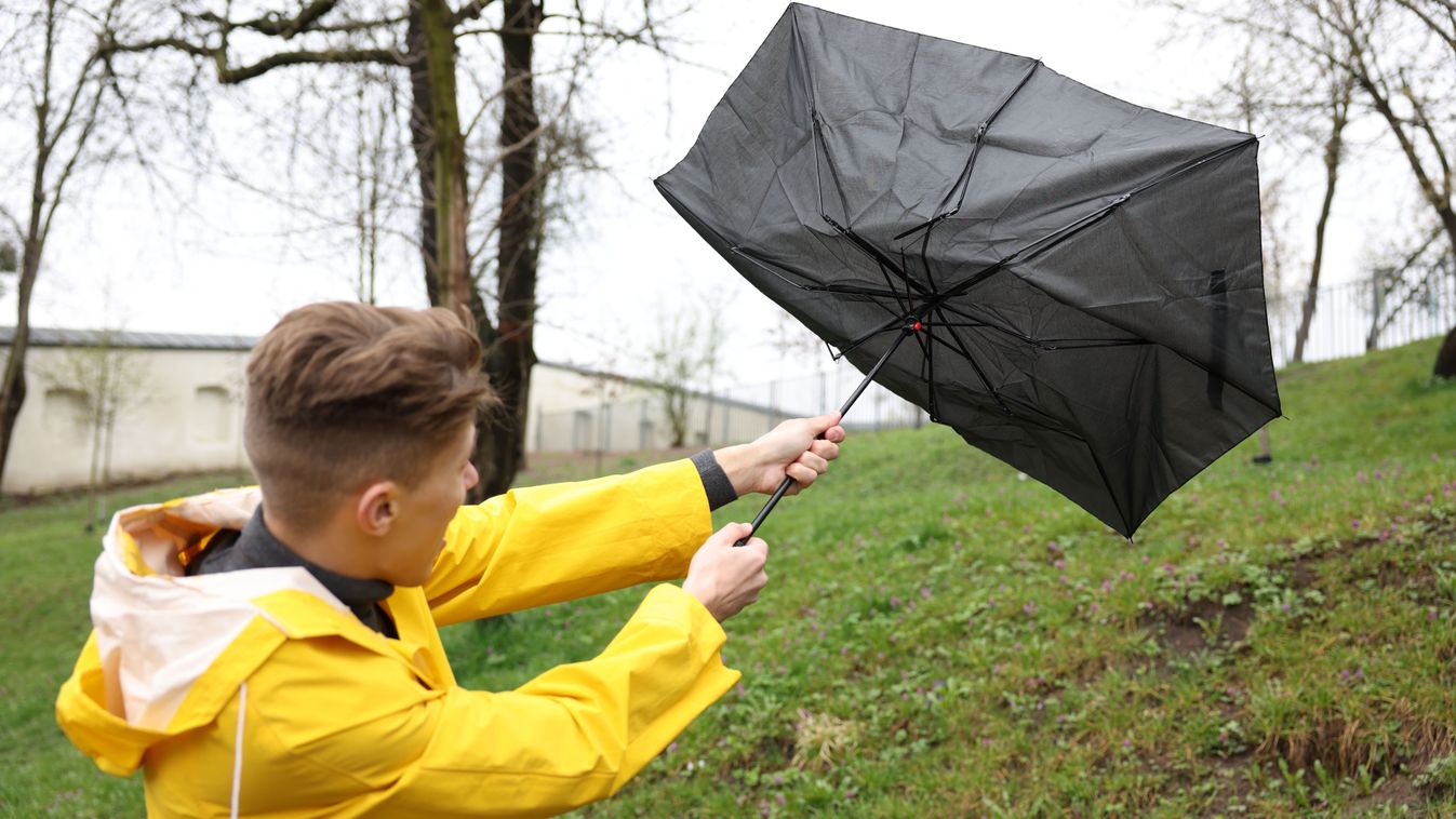 Man with broken umbrella fighting wind under rain outdoors

2610209347