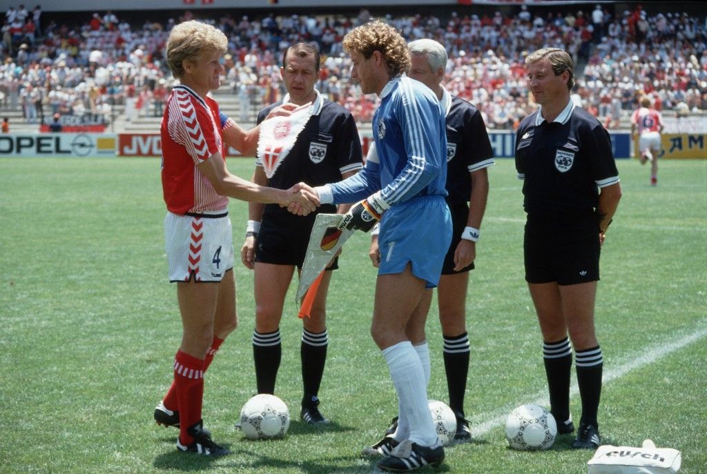 The two team captains of Germany and Denmark, German goalkeeper Harald "Toni" Schumacher and Denmark's Morten Olsen are exchanging pennants prior to the match in Queretaro during the 1986 FIFA World Cup in Mexico. (Photo by WEREK / R3690_WEREK / dpa Picture-Alliance via AFP)