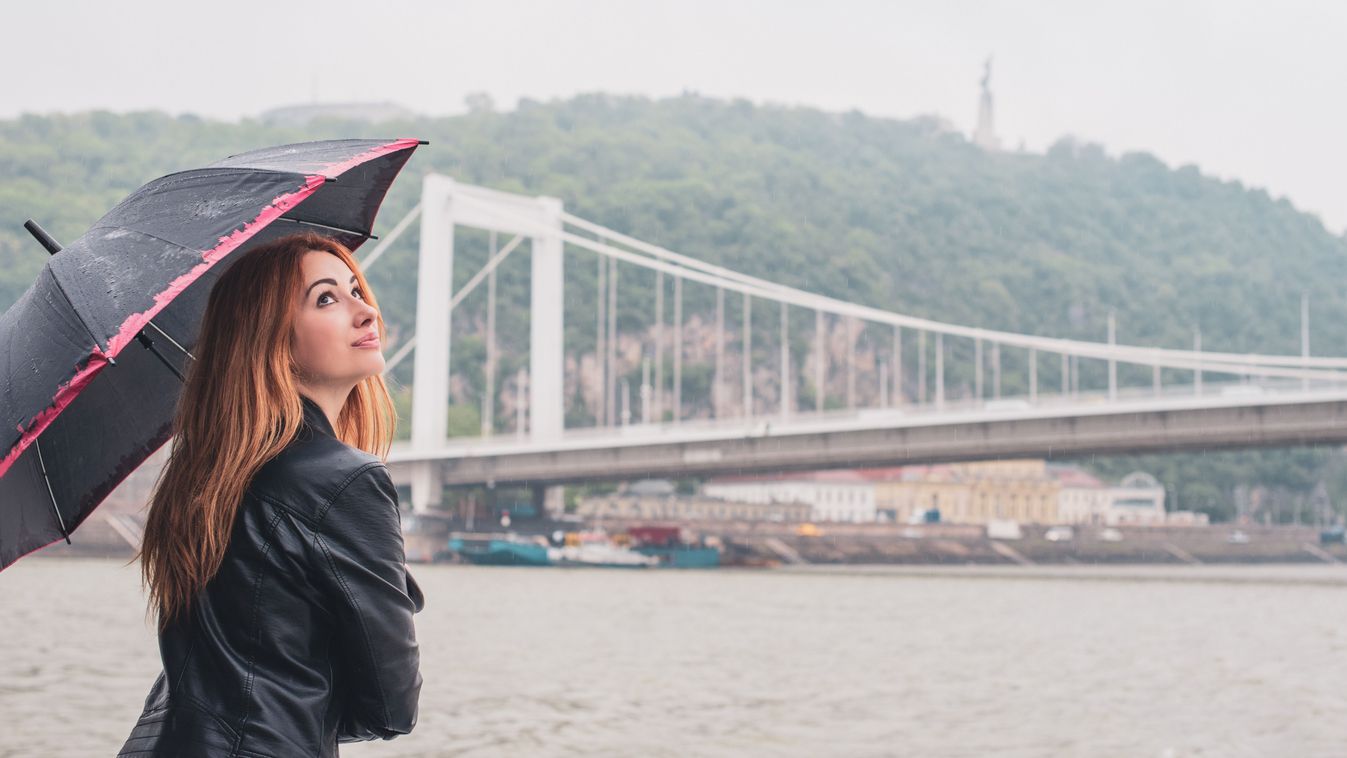 Tourism concept. Beautiful woman look at view of city streets, centre of city with umbrella . Vacation in Budapest

1469613095