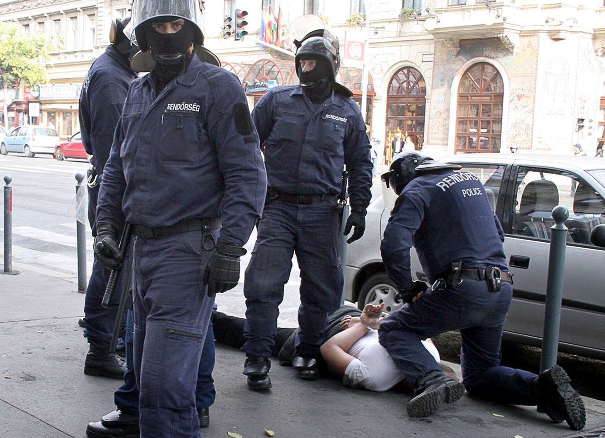 A local demonstrator is arrested by police on Terez Boulevard in downtown Budapest, 23 October 2006 as thousands of protestor took to the streets as the country commemorates the 50th anniversary of the 1956 uprising and war of independence against communist rule and Soviet Union. The Hungarian uprising erupted on 23 October 1956 and was crushed by Soviet tanks on 04 November, sealing the country's fate as a satellite state of Moscow until the wall of the Iron Curtain in 1989.
 AFP PHOTO / STR / Nandyred (Photo by NANDYRED / AFP)