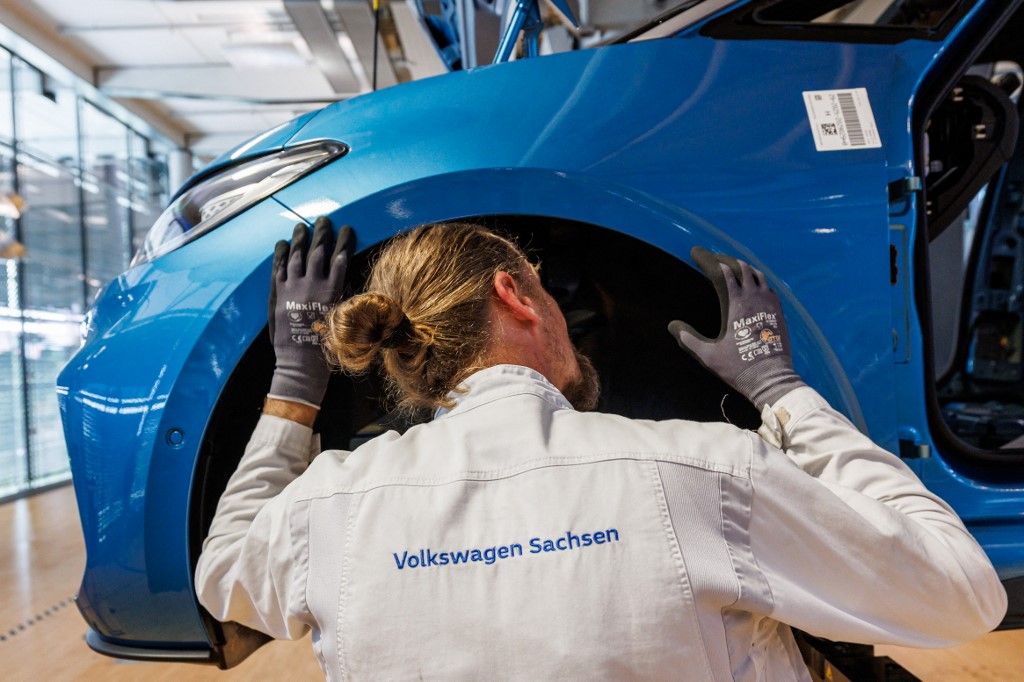 Employees work on the assembly line for the Volkswagen (VW) ID.3 electric car of German carmaker Volkswagen, at the 'Transparent Factory' (Glaeserne Manufaktur) production site of German carmaker Volkswagen (VW) in Dresden, eastern Germany, on May 14, 2025. The Volkswagen Group is planning to discontinue car production at the factory at the end of 2025. (Photo by JENS SCHLUETER / AFP)